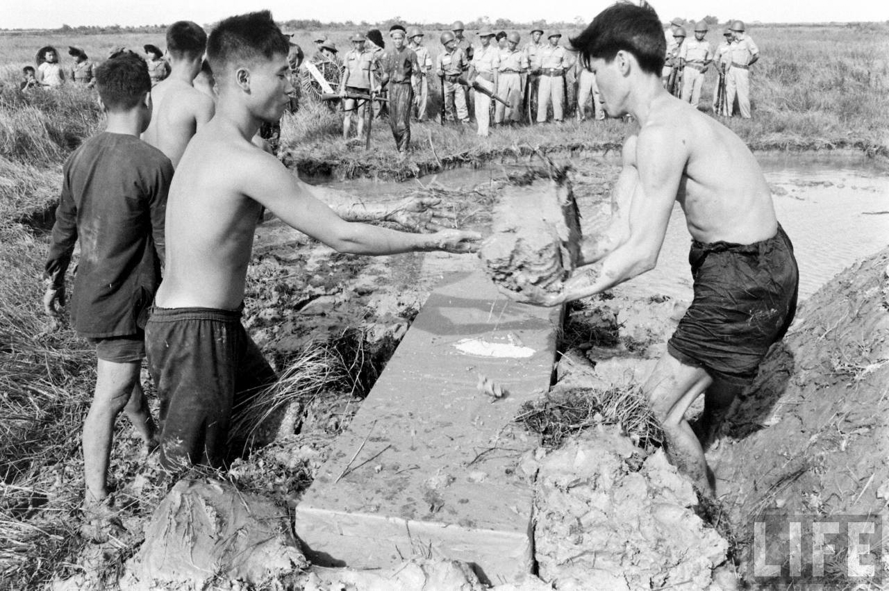 Người dân Cà Mau đắp đất vào quan tài năm 1961 - ảnh chụp Howard Sochurek