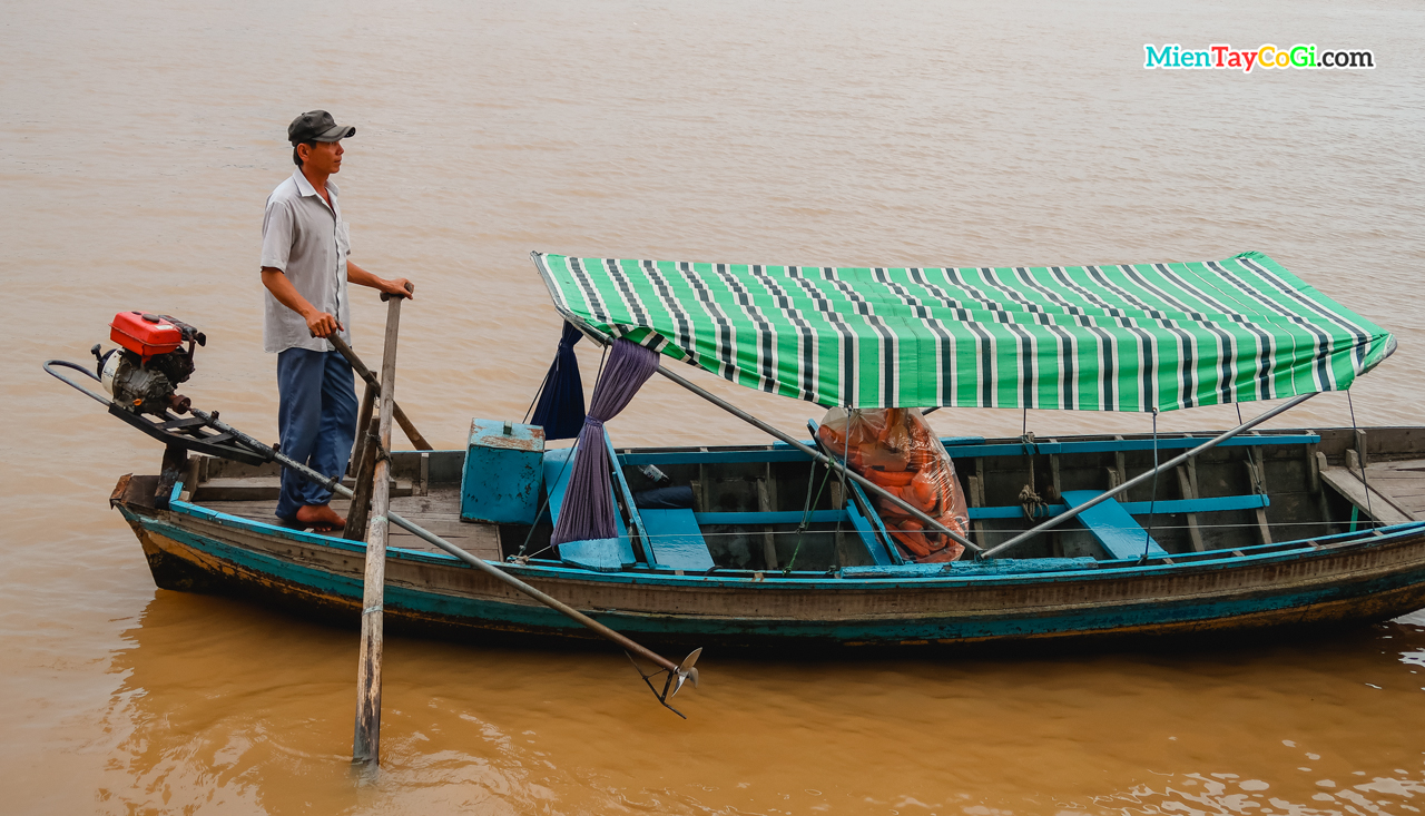 Người đàn ông lái thuyền nhỏ chờ khách du lịch ở bến Ninh Kiều