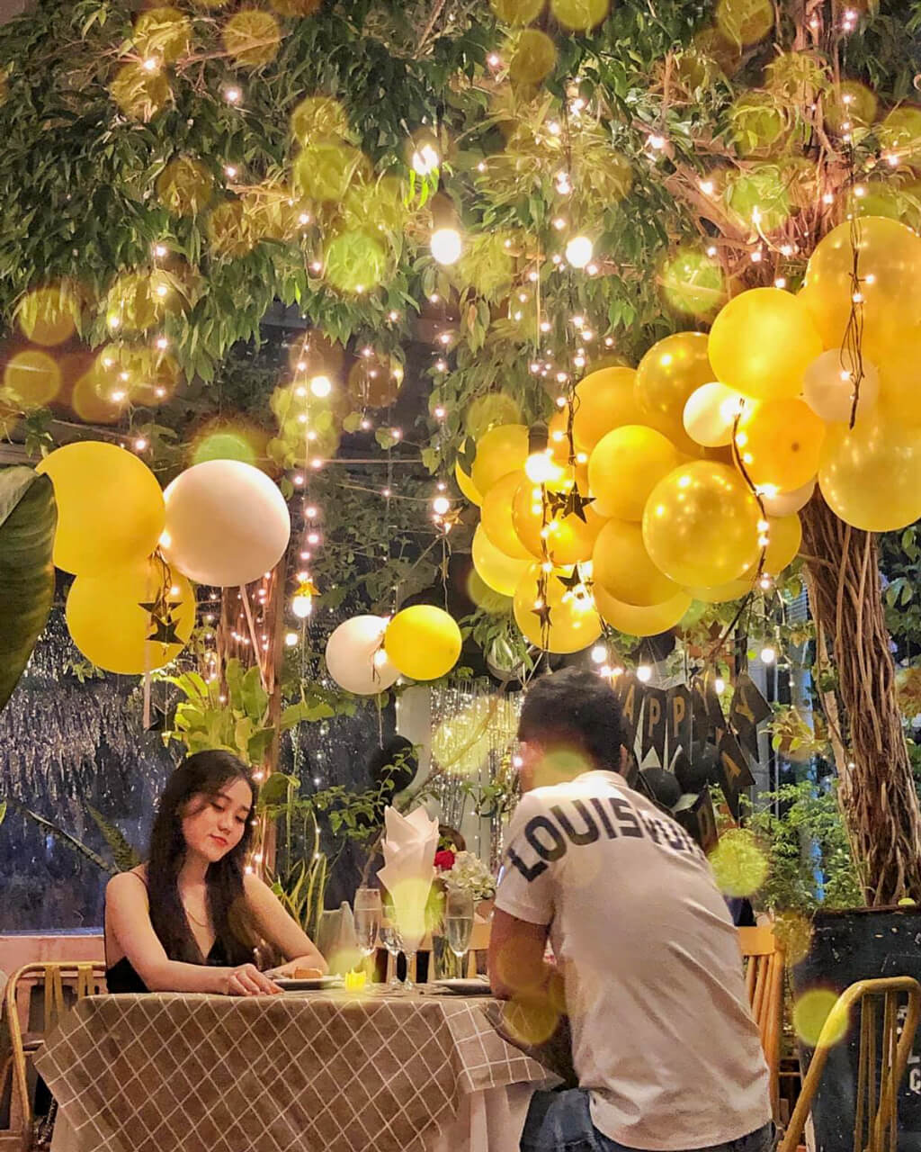 Cặp đôi ăn tối dưới gốc cây trang trí lãng mạn tại Ma Famille Cafeteria